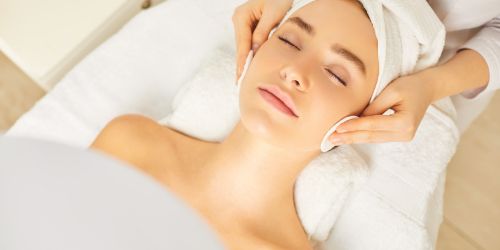 Close-up of a woman's face receiving a deep cleansing facial at DermaGlow Esthetics, showcasing clean and glowing skin.